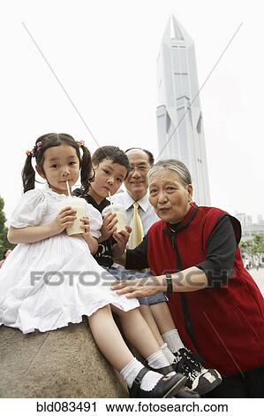 Stock Image - Chinese grandparents enjoying grandchildren. Fotosearch