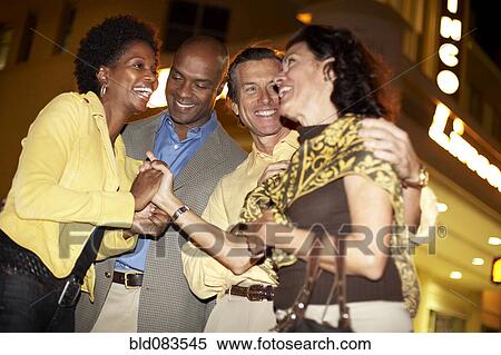 Stock Photography - Couples socializing together at night. Fotosearch