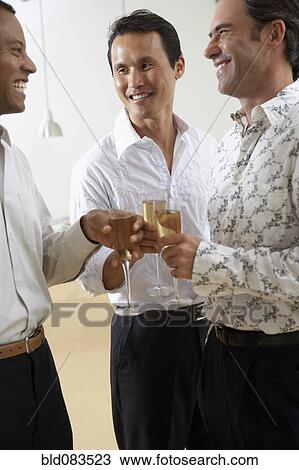 Stock Image - Friends celebrating with Champagne together. Fotosearch