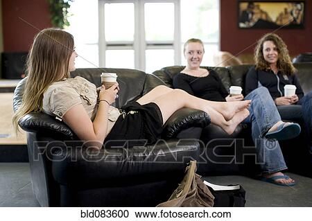 Stock Image - Friends drinking coffee in cafe. Fotosearch