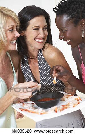 Friends eating shrimp together at party View Large Photo Image Stock Image - Friends eating shrimp together at party. Fotosearch