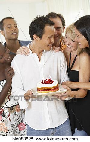 Friends surprising man with birthday cake View Large Photo Image Stock Photography - Friends surprising man with birthday cake. Fotosearch
