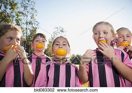 Girl soccer players eating orange slices View Large Photo Image Stock Image - Girl soccer players eating orange slices. Fotosearch