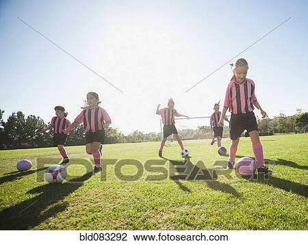 Stock Image - Girl soccer players practicing with soccer balls. Fotosearch