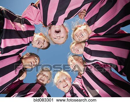 Stock Image - Girl soccer players standing in circle. Fotosearch