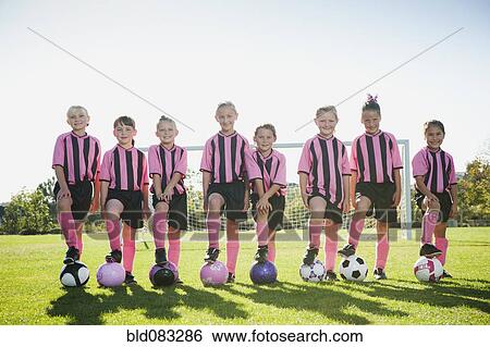 Girl soccer players standing with feet on soccer balls View Large Photo Image Stock Photograph - Girl soccer players standing with feet on soccer balls. Fotosearch