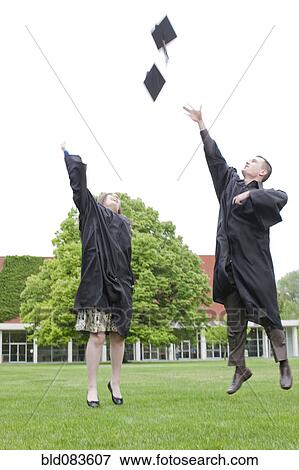 Graduates throwing graduation caps into air View Large Photo Image Stock Photo - Graduates throwing graduation caps into air. Fotosearch