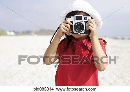 Hispanic girl using old-fashioned camera on beach View Large Photo Image Picture - Hispanic girl using old-fashioned camera on beach. Fotosearch