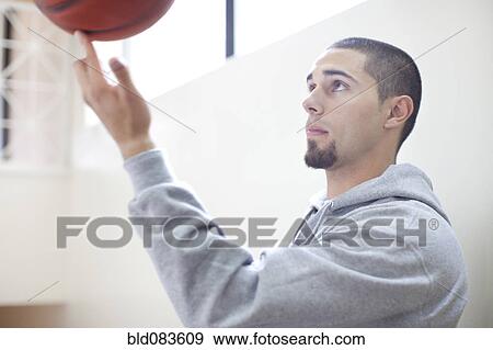 Hispanic man spinning basketball on finger View Large Photo Image Stock Photo - Hispanic man spinning basketball on finger. Fotosearch
