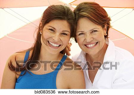 Stock Photograph - Hispanic mother and daughter smiling. Fotosearch