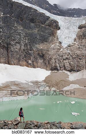 Stock Photo - Hispanic woman hiking hear glacial lake. Fotosearch