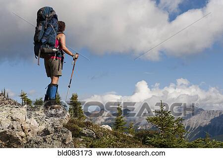 Stock Image - Hispanic woman hiking near mountain. Fotosearch