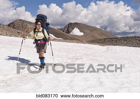 Stock Image - Hispanic woman hiking over snow. Fotosearch