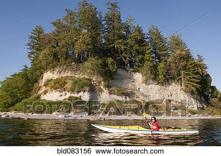 Stock Photograph - Hispanic woman kayaking on lake. Fotosearch