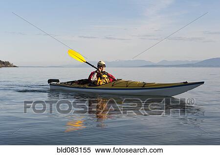 Stock Photography - Hispanic woman kayaking on lake. Fotosearch