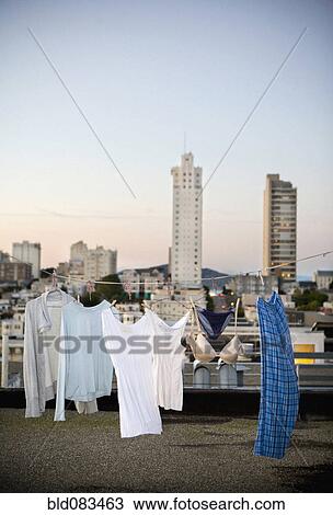 Stock Image - Laundry on clothes line on urban rooftop. Fotosearch