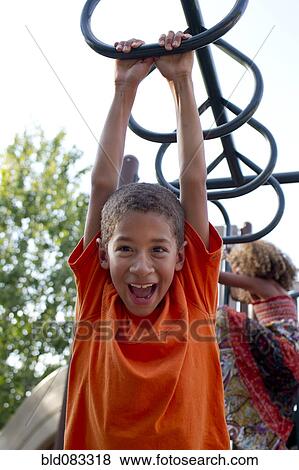 Mixed race boy playing on playground View Large Photo Image Stock Photo - Mixed race boy playing on playground. Fotosearch