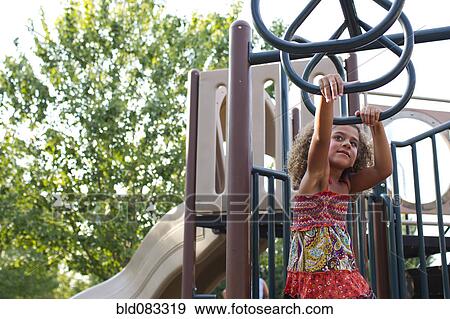 Stock Photo - Mixed race girl playing on playground. Fotosearch