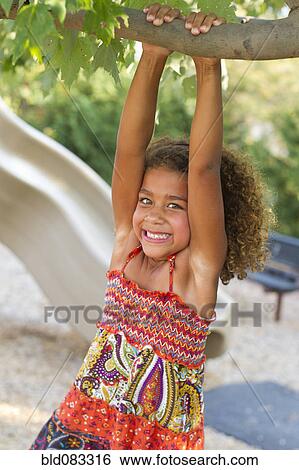 Stock Photograph - Mixed race girl playing on playground. Fotosearch