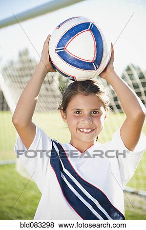 Stock Photo - Mixed race girl soccer player holding soccer ball. Fotosearch