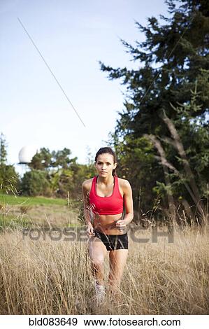 Stock Photo - Mixed race jogger running through field. Fotosearch