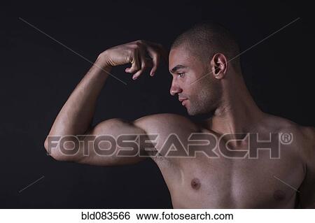 Stock Photograph - Mixed race man flexing biceps. Fotosearch