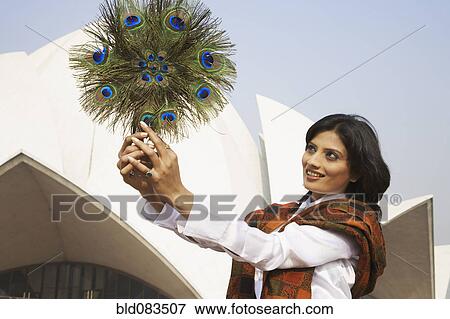 Mixed race woman holding peacock feather fan View Large Photo Image Stock Photo - Mixed race woman holding peacock feather fan. Fotosearch