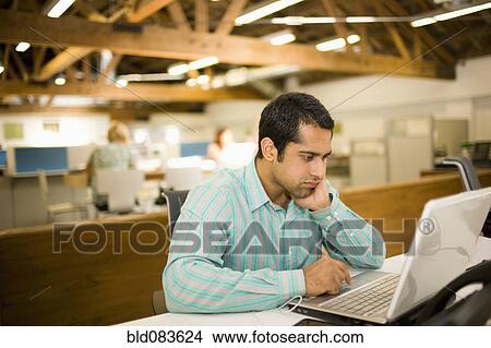 Pacific Islander businessman using laptop in communal workspace View Large Photo Image Picture - Pacific Islander businessman using laptop in communal workspace. Fotosearch