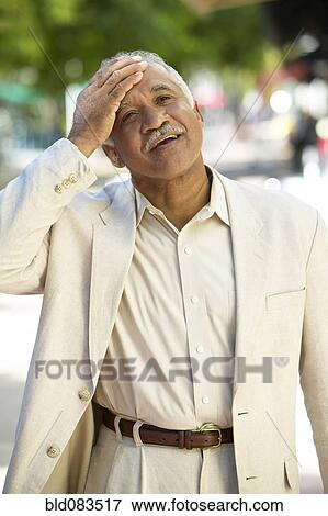 Relieved Hispanic man standing outdoors View Large Photo Image Stock Photo - Relieved Hispanic man standing outdoors. Fotosearch