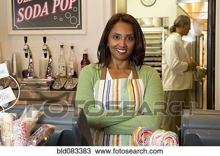 Stock Image - Small business owners standing in bakery shop. Fotosearch