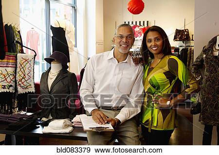 Stock Photo - Small business owners standing in clothing shop. Fotosearch