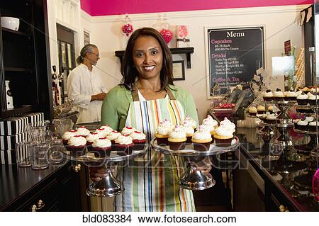 Small business owners with cupcakes in bakery shop View Large Photo Image Picture - Small business owners with cupcakes in bakery shop. Fotosearch
