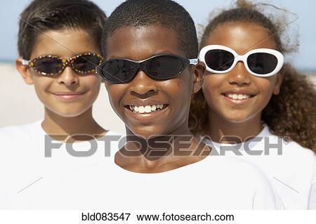 Smiling children wearing sunglasses View Large Photo Image Stock Photo - Smiling children wearing sunglasses. Fotosearch