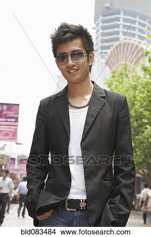 Smiling Chinese man standing outdoors View Large Photo Image Picture - Smiling Chinese man standing outdoors. Fotosearch