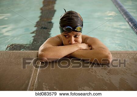 Unhappy Pacific Islander swimmer leaning at edge of pool View Large Photo Image Stock Photo - Unhappy Pacific Islander swimmer leaning at edge of pool. Fotosearch