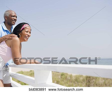 Stock Image - Black couple enjoying beach together. Fotosearch