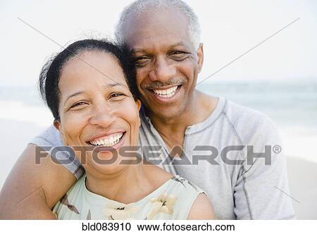 Stock Image - Black couple enjoying beach together. Fotosearch
