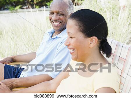 Black couple laughing outdoors together View Large Photo Image Stock Photograph - Black couple laughing outdoors together. Fotosearch