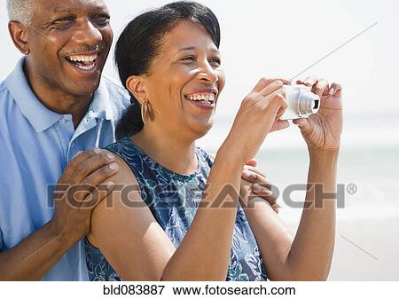 Black couple taking pictures on beach View Large Photo Image Stock Photo - Black couple taking pictures on beach. Fotosearch