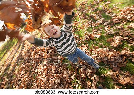 Caucasian boy throwing autumn leaves View Large Photo Image Stock Image - Caucasian boy throwing autumn leaves. Fotosearch