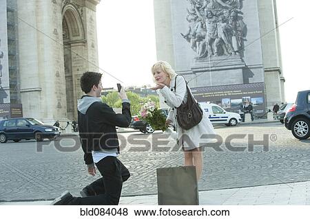 Caucasian man taking photograph of girlfriend near Arc de Triomphe View Large Photo Image Stock Photo - Caucasian man taking photograph of girlfriend near Arc de Triomphe. Fotosearch
