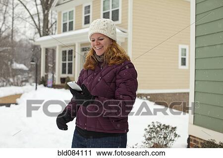 Caucasian woman using cell phone in snow View Large Photo Image Stock Image - Caucasian woman using cell phone in snow. Fotosearch