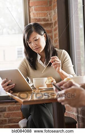Chinese woman using digital tablet in cafe View Large Photo Image Stock Photo - Chinese woman using digital tablet in cafe. Fotosearch