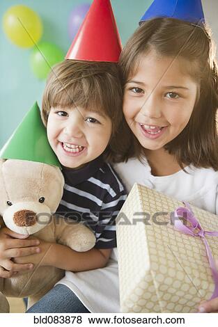 Stock Photo - Hispanic brother and sister at birthday party. Fotosearch