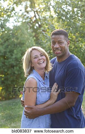 Stock Photo - Interracial couple hugging. Fotosearch