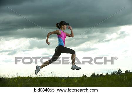 Stock Photography - Japanese woman running in field. Fotosearch