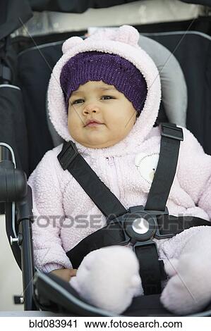 Stock Image - Mixed race baby in car seat. Fotosearch