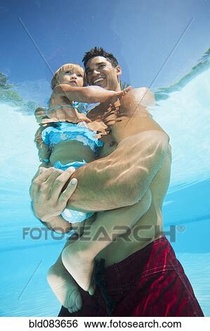 Mixed race father holding daughter in swimming pool View Large Photo Image Stock Photograph - Mixed race father holding daughter in swimming pool. Fotosearch