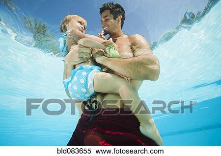 Mixed race father holding daughter in swimming pool View Large Photo Image Stock Photography - Mixed race father holding daughter in swimming pool. Fotosearch