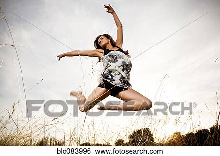 Mixed race woman jumping in mid-air outdoors View Large Photo Image Stock Photograph - Mixed race woman jumping in mid-air outdoors. Fotosearch